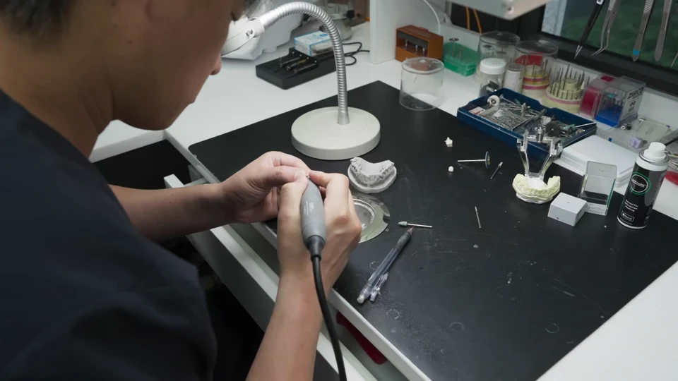 作業台で補綴物を整える技工室長